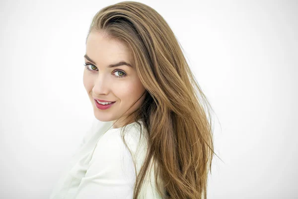 Mulher feliz bonita jovem posando contra uma parede branca — Fotografia de Stock