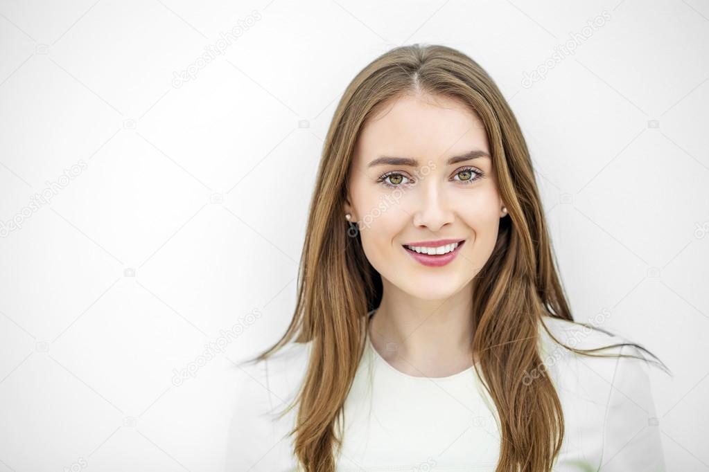 Beautiful young happy woman posing against a white wall