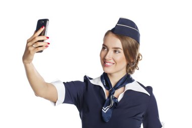Mutlu genç hostes beyaz b izole bir akıllı telefon tutarak