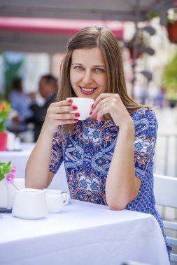 Bir kafede oturan mutlu güzel esmer kız