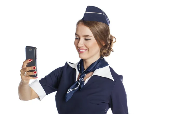 Gelukkig jonge stewardess houden een slimme telefoon geïsoleerd op witte b — Stockfoto