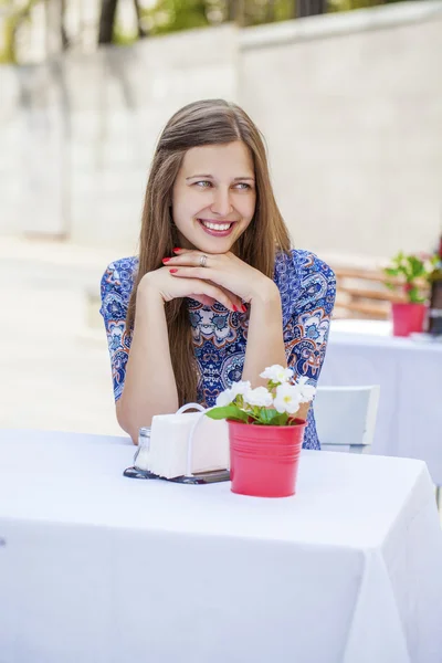 Glada vackra brunett tjej sitter på ett kafé — Stockfoto