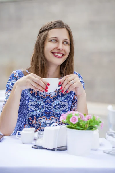 Šťastná krásná bruneta dívka sedí v kavárně — Stock fotografie