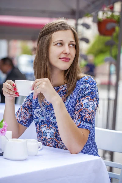 Щаслива красива дівчина брюнетка сидить у кав'ярні — стокове фото