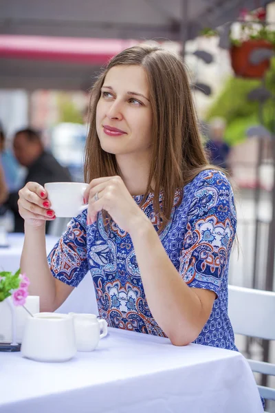Šťastná krásná bruneta dívka sedí v kavárně — Stock fotografie