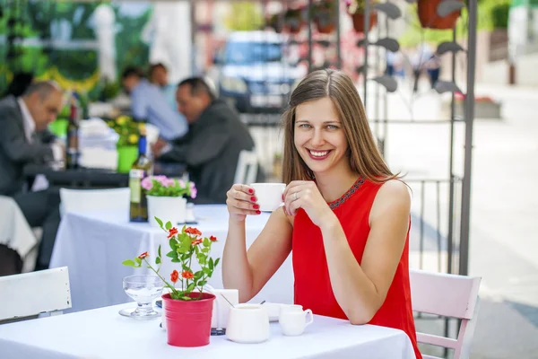 Vacker brunett flicka sitter på ett kafé — Stockfoto