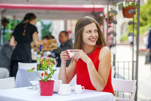 Vacker brunett flicka sitter på ett kafé — Stockfoto