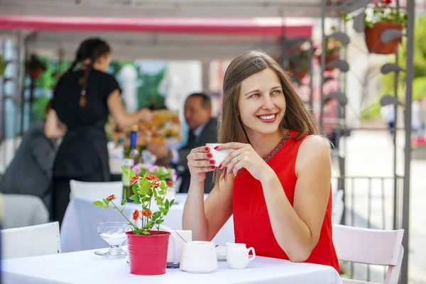 Mooie brunette meisje, zittend in een koffieshop — Stockfoto