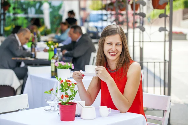 Bella ragazza bruna seduta in una caffetteria — Foto Stock