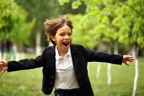 夏の公園で走ったりして幸せな小さなブルネット少年 — ストック写真