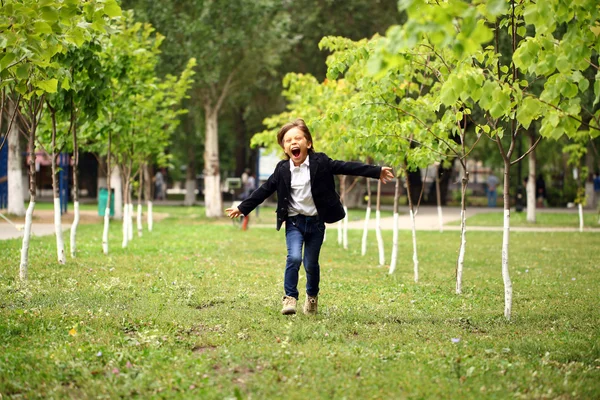 Menino morena feliz corre em um parque de verão — Fotografia de Stock