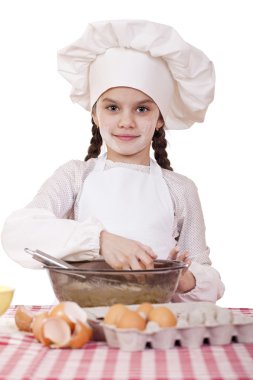 Küçük aşçı kız beyaz bir önlük yumurtaları derin bir tabak içinde tatili.