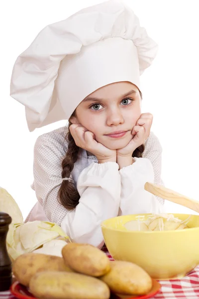 Belle petite cuisinière en chef sur le bureau avec des légumes — Photo