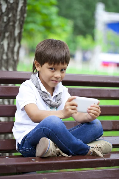Little boy intently playing games on smartphone — Stock Photo, Image