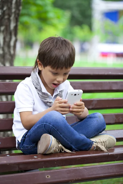 Chlapeček soustředěně hraní her na smartphone — Stock fotografie