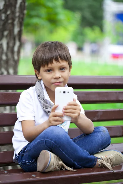 Weinig glimlachend kind jongen hand met GSM of smartphone — Stockfoto