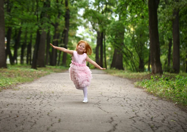 Menina feliz corre em um parque de verão — Fotografia de Stock
