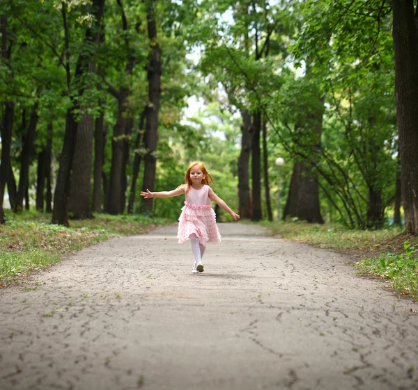 Happy little girl runs in a summer park — Stock Photo, Image