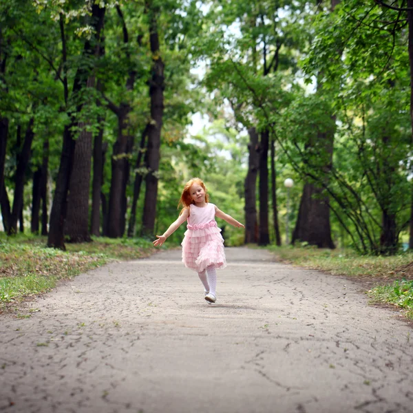 Menina feliz corre em um parque de verão — Fotografia de Stock