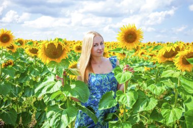 Güzel bir sarışın genç kadın bir ba üzerinde mavi elbiseli portresi