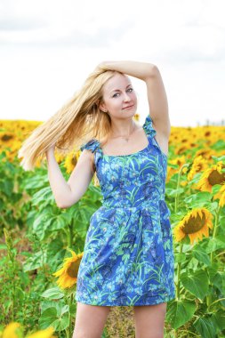 Güzel bir sarışın genç kadın bir ba üzerinde mavi elbiseli portresi