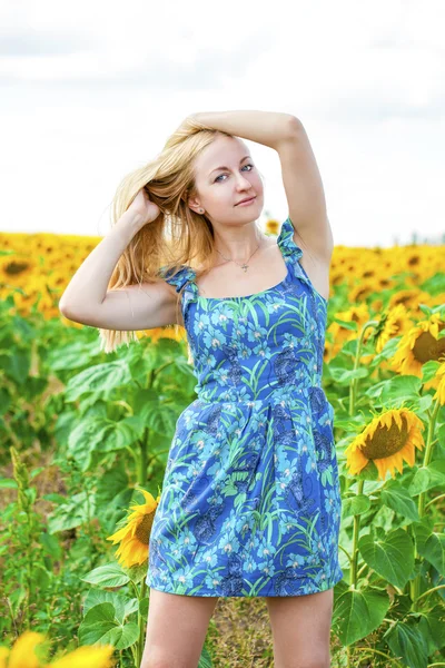 Portrait of a beautiful young blonde woman in blue dress on a ba — Stock Photo, Image