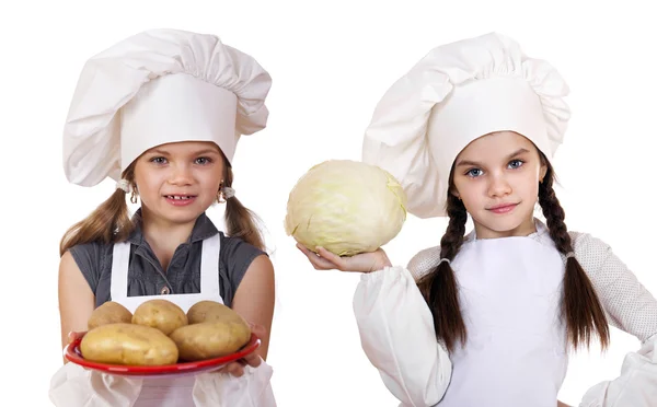 Koken en mensen concept - twee kleine meisjes in een wit schort — Stockfoto