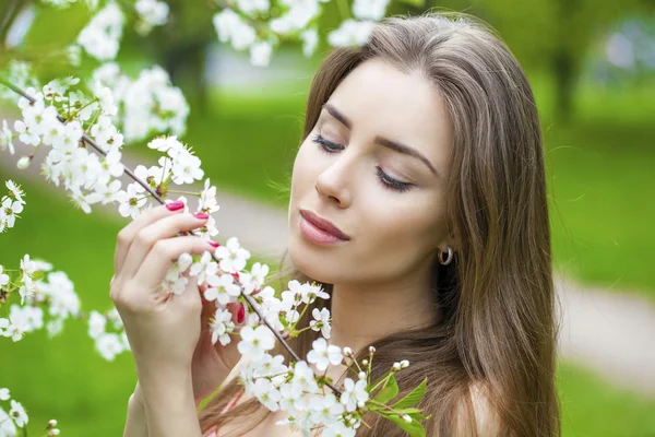 春の花で美しい若いブルネットの女性の肖像画 — ストック写真