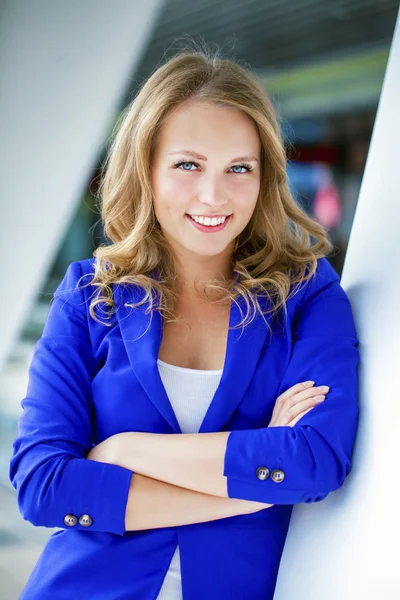 Mooie jonge blonde in een blauwe jas — Stockfoto