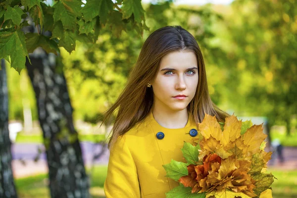 Mutlu genç kadın sarı montlu sonbahar Park — Stok fotoğraf