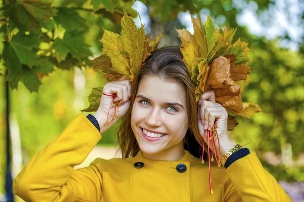 Joyeux jeune femme en manteau jaune dans le parc d'automne — Photo