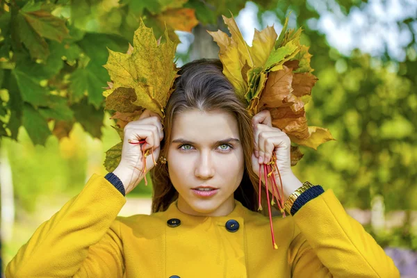 Mujer joven feliz en abrigo amarillo en el parque de otoño — Foto de Stock