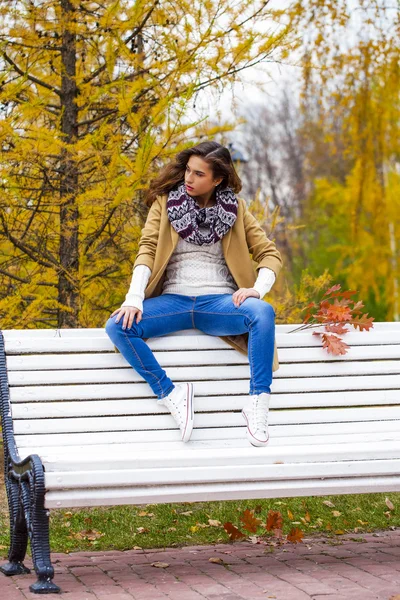 秋の公園でベンチに座っている美しい女性 — ストック写真