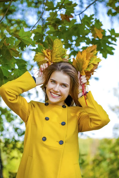 Joyeux jeune femme en manteau jaune dans le parc d'automne — Photo