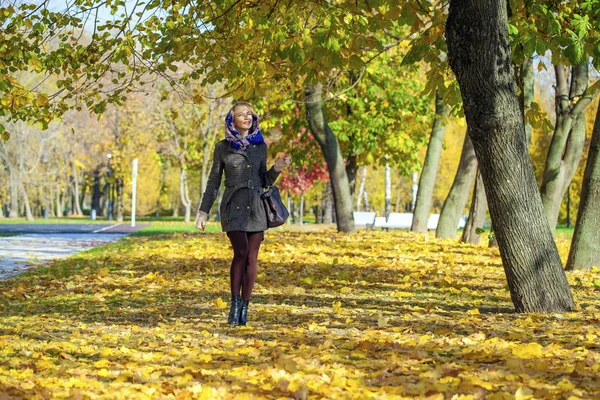 Mladá žena kráčí v podzimním parku — Stock fotografie