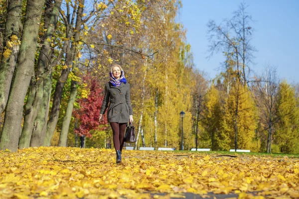 Giovane donna che cammina nel parco autunnale — Foto Stock