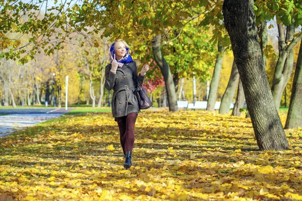 Ung kvinna promenader i höstparken — Stockfoto