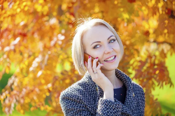 Porträtt av en vacker ung kvinna ringer via telefon — Stockfoto