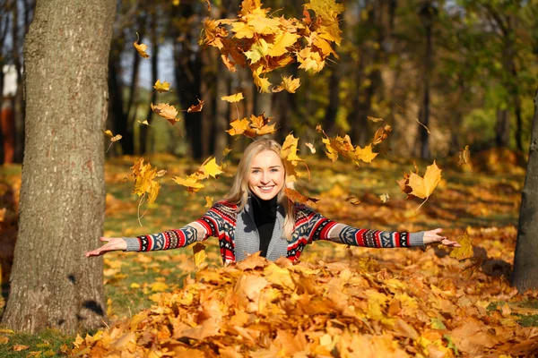 Glückliche Frau wirft Blätter im Herbstpark ab — Stockfoto