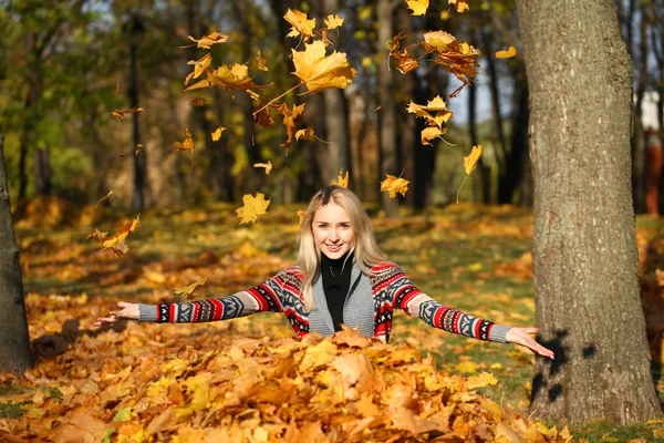 Happy woman drop up leaves in autumn park — Stock Photo, Image