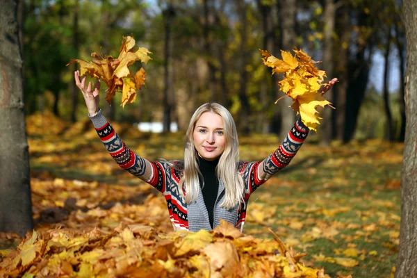 Glückliche Frau wirft Blätter im Herbstpark ab — Stockfoto