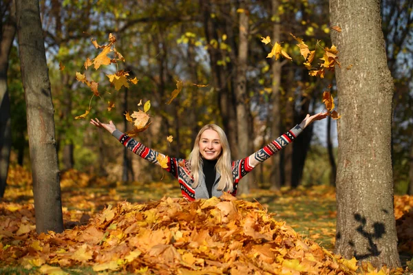 Gelukkige vrouw daling omhoog bladeren in de herfst park — Stockfoto