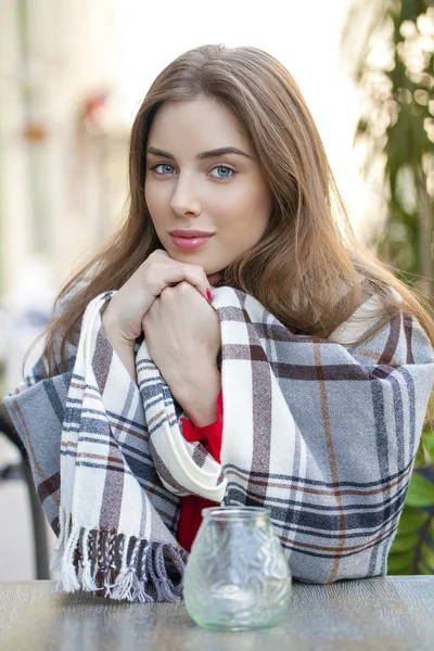 Portrait of a beautiful young girl sitting in a cafe on the stre — Stock Photo, Image