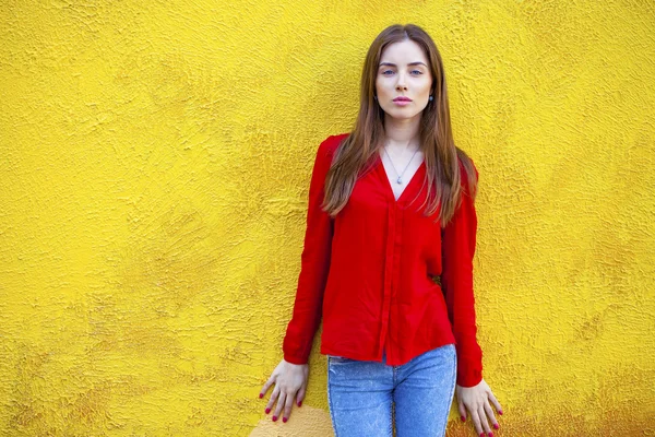 Mujer joven atractiva, contra el fondo de la pared amarilla —  Fotos de Stock