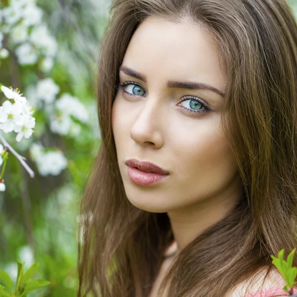 Retrato de una hermosa joven morena en flor de primavera — Foto de Stock