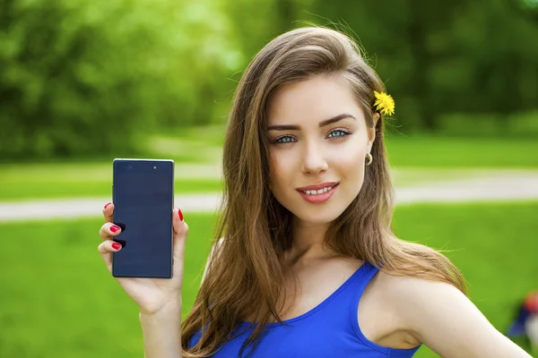 Jonge mooie brunette vrouw toont een nieuwe slimme telefoon — Stockfoto