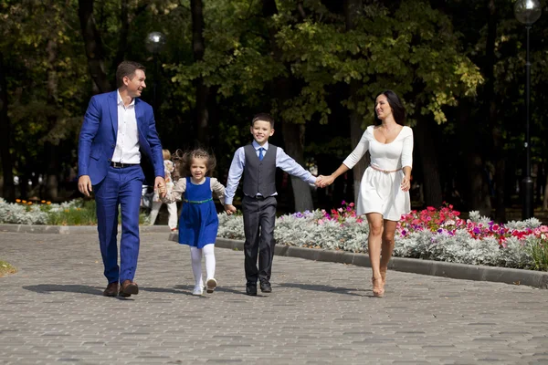 Felice famiglia a piedi lungo la strada suburbana — Foto Stock