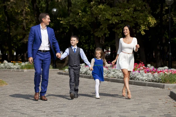Felice famiglia a piedi lungo la strada suburbana — Foto Stock