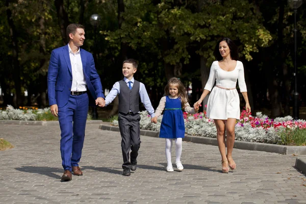 Glückliche Familie spaziert die Vorstadtstraße entlang — Stockfoto