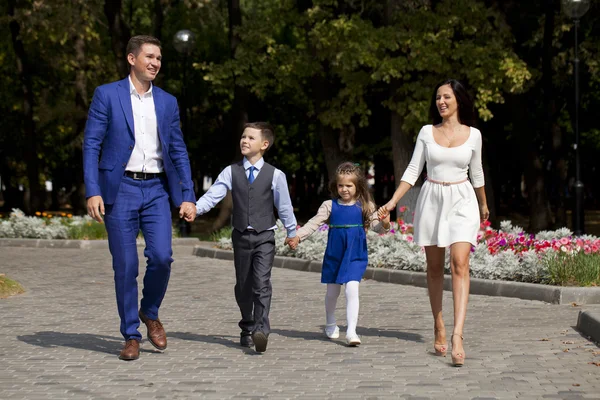 Felice famiglia a piedi lungo la strada suburbana — Foto Stock